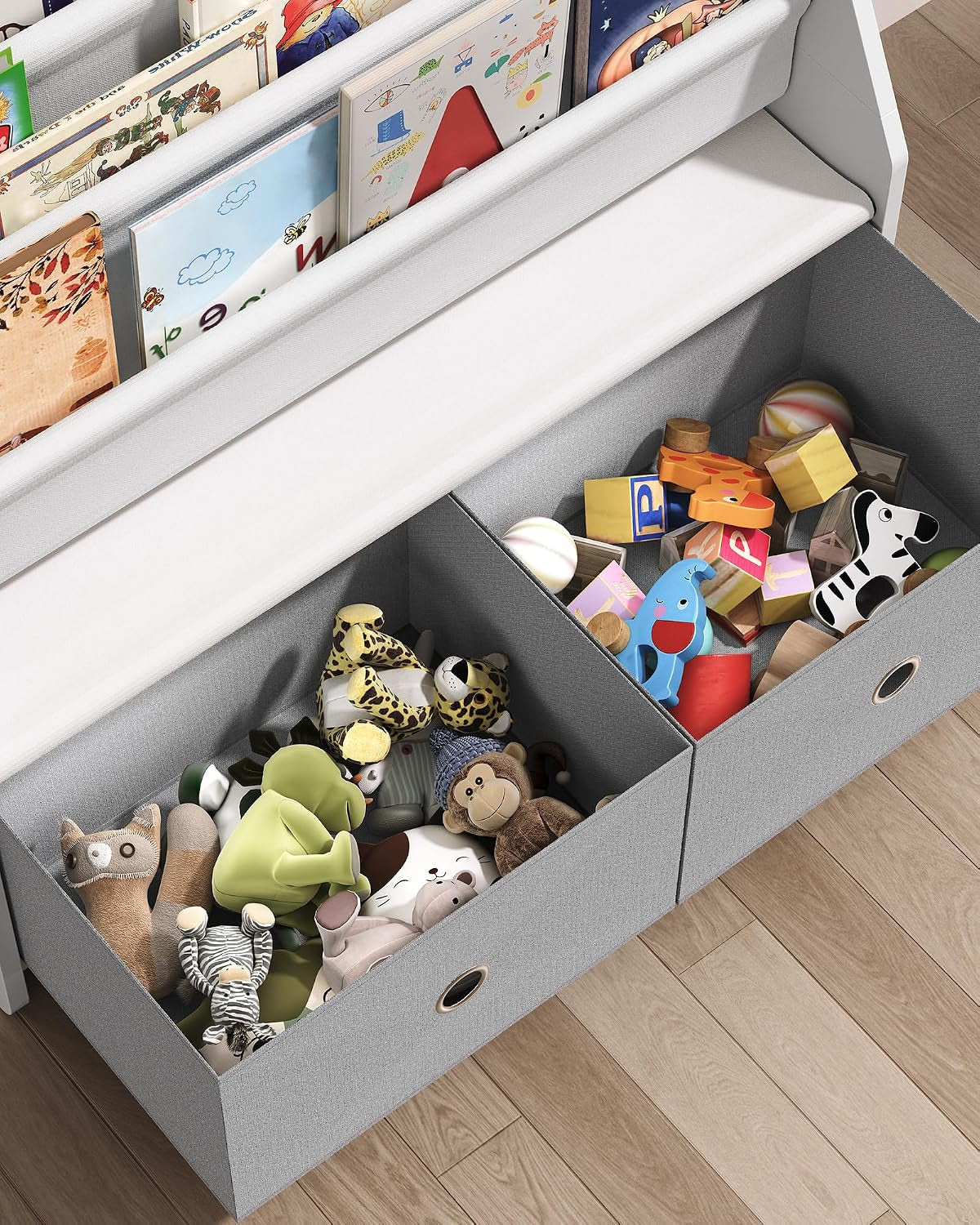Two gray fabric pull-out bins under the shelf filled with stuffed animals, blocks and toys.