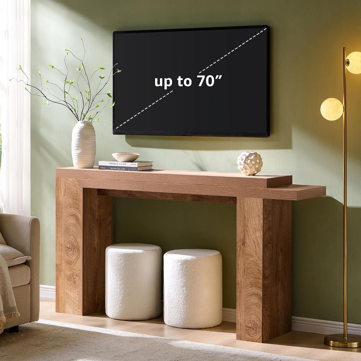 Styled living room scene with console table beneath a mounted TV and two round ottomans tucked underneath