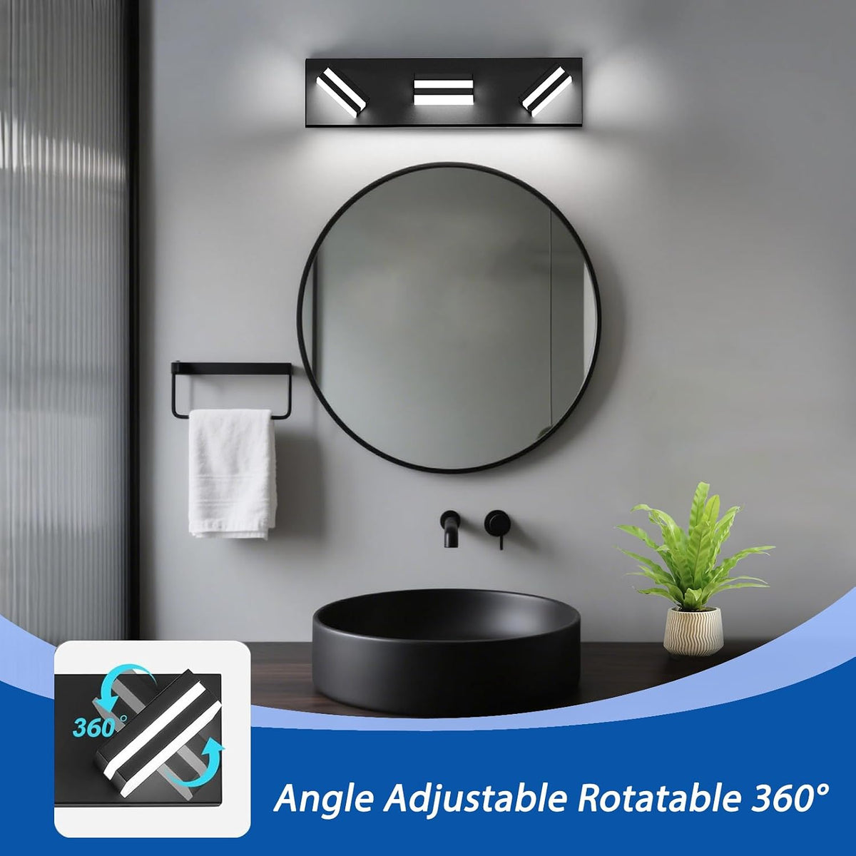 Round wall mirror above a black sink with a black three-light LED vanity light mounted above and a towel rack at left.