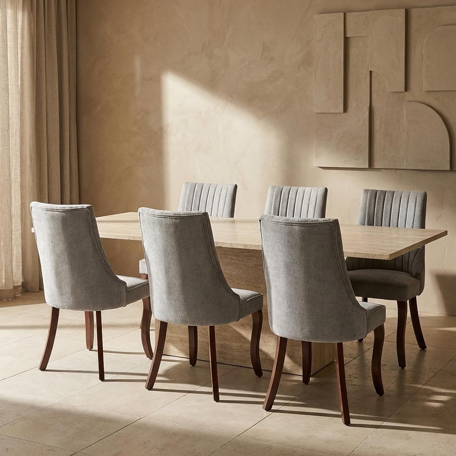 Six beige upholstered dining chairs with dark wood legs around a rectangular stone table