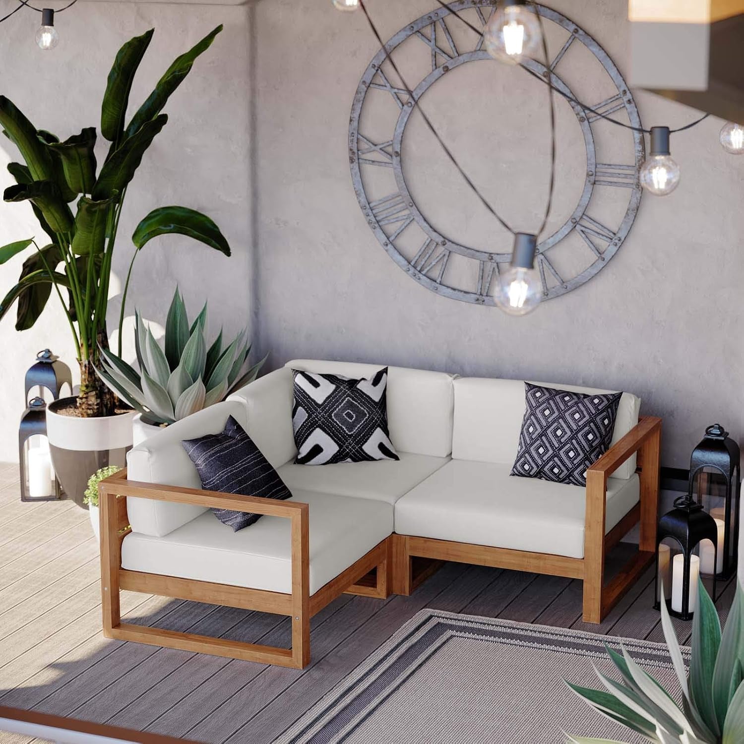 L-shaped teak corner sofa under a large wall clock with patterned pillows and potted plants