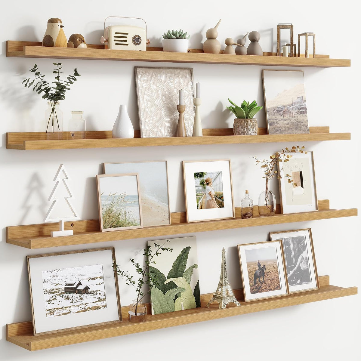 Angled view of three warm wood ledges with small sculptures, a radio and framed prints.