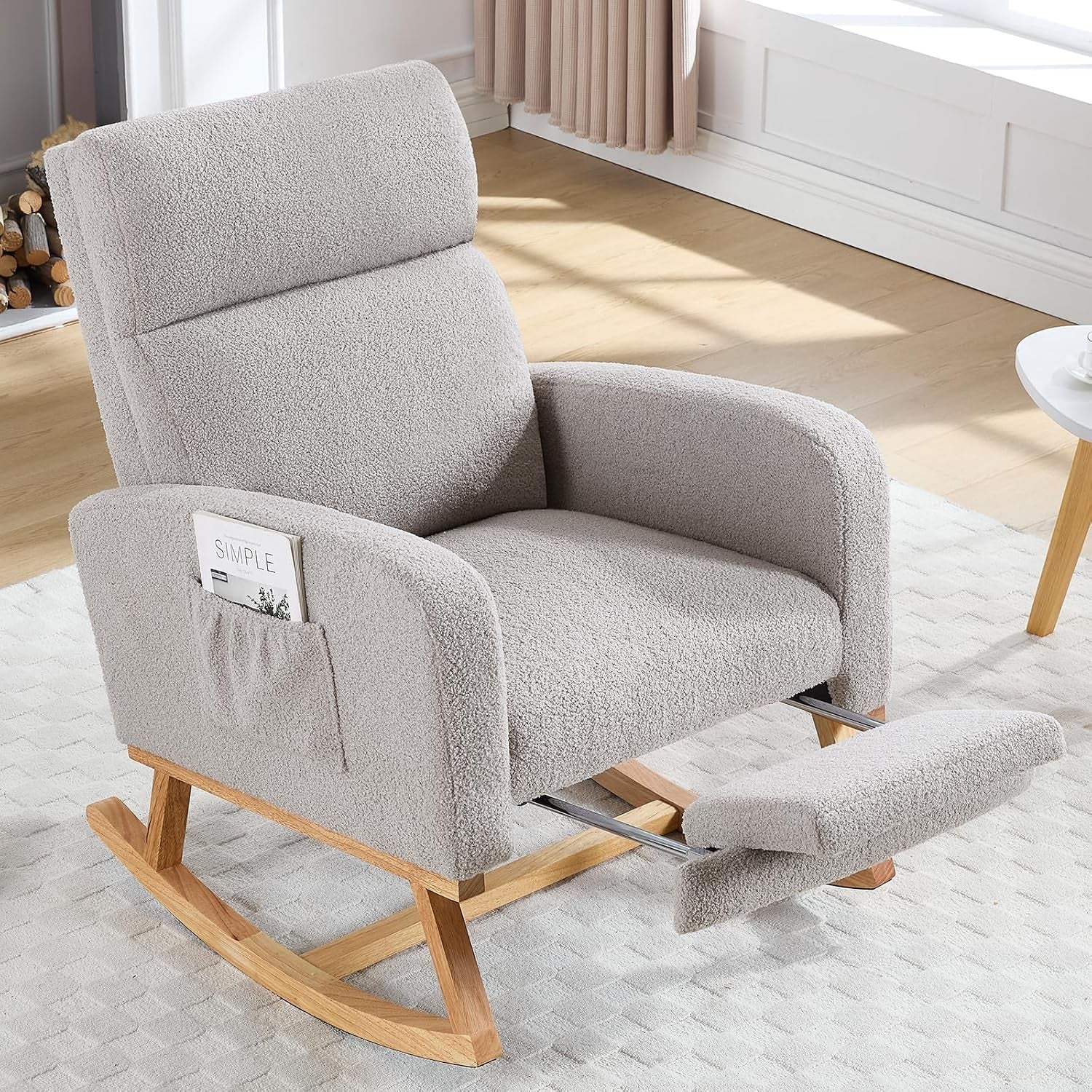 Beige upholstered rocking glider with extended footrest and pocket on arm, on a light rug