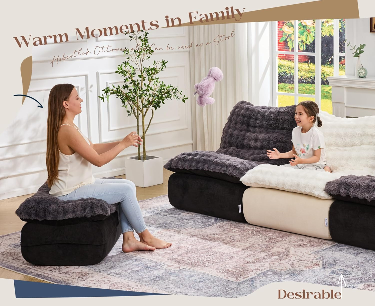 Living room scene with a woman seated on a dark ottoman and a child on a matching plush sofa.