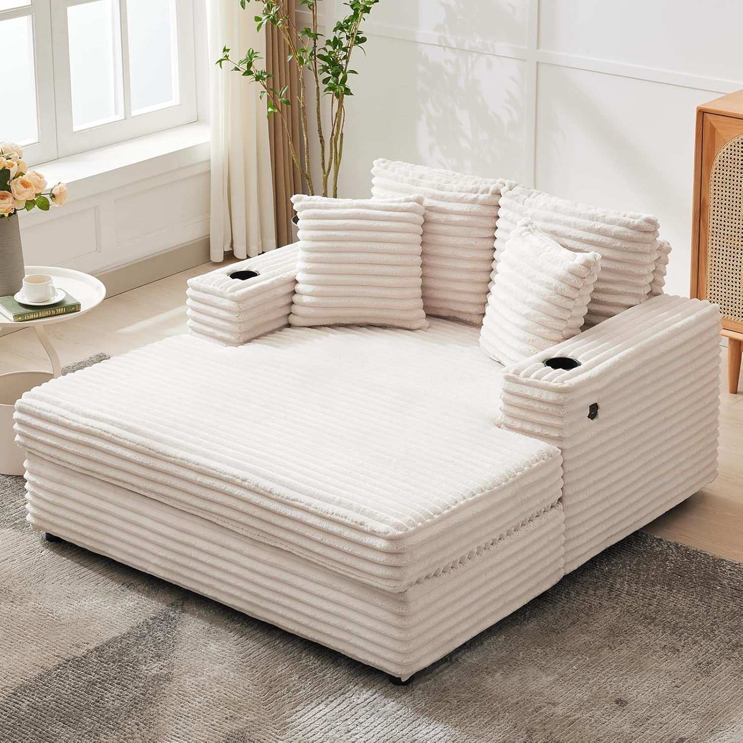 Cream oversized corduroy chaise with cup holders and ribbed cushions in a bright living room.