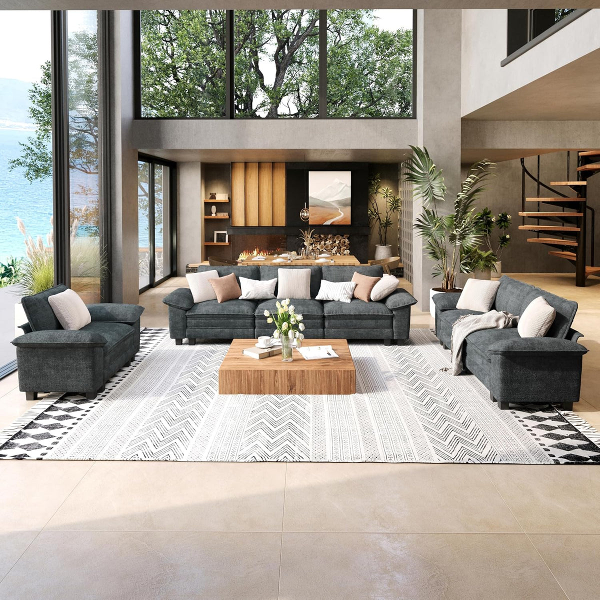 Front-facing view of a three-seat couch and loveseat in dark chenille fabric on a large patterned rug with tall windows