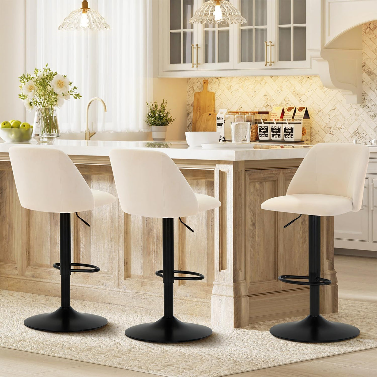 Three cream-colored swivel stools and one angled stool along a wooden island beneath pendant lighting.
