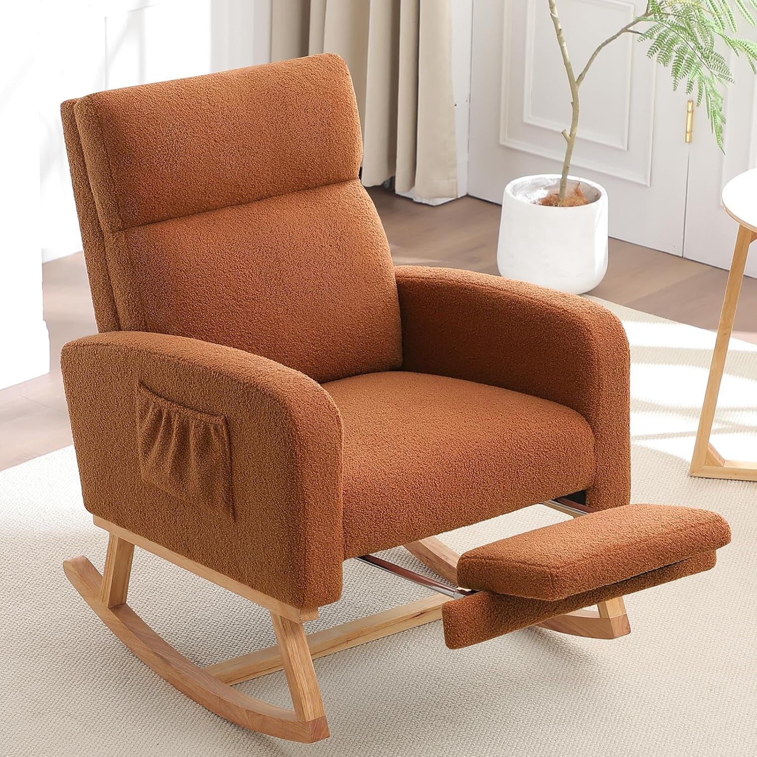 Warm brown/rust upholstered rocking chair on light rug with matching extended footrest.