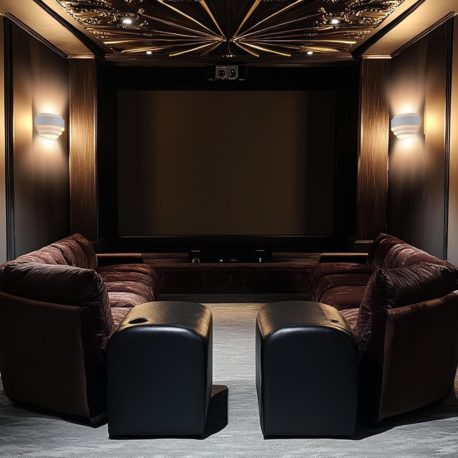 Two white layered wall sconces glowing on dark paneled walls of a home theater room.