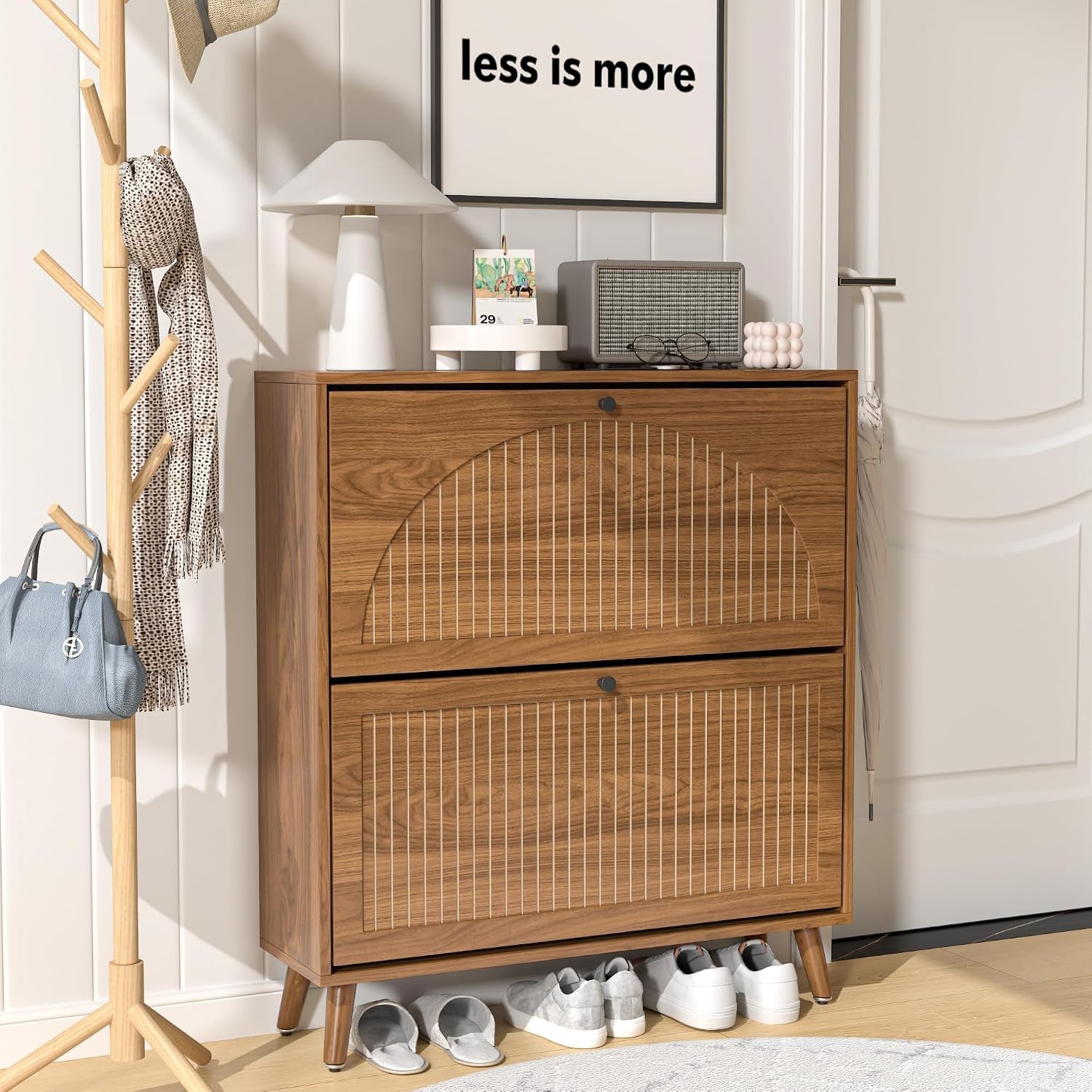 Walnut-finish two-drawer shoe cabinet with fluted semicircle detail in a hallway setting