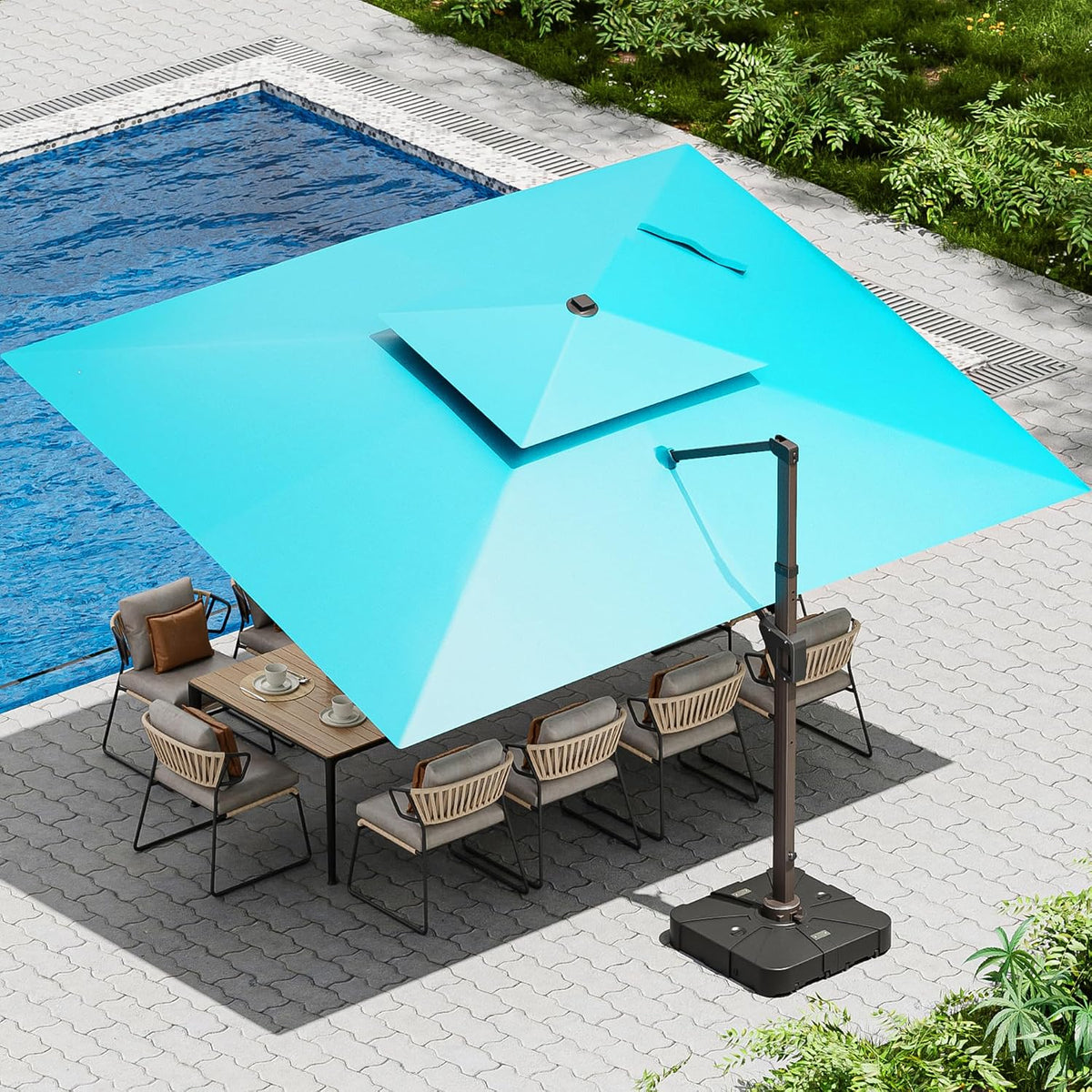 Aerial view of a light blue square cantilever umbrella shading a patio dining area by a pool.