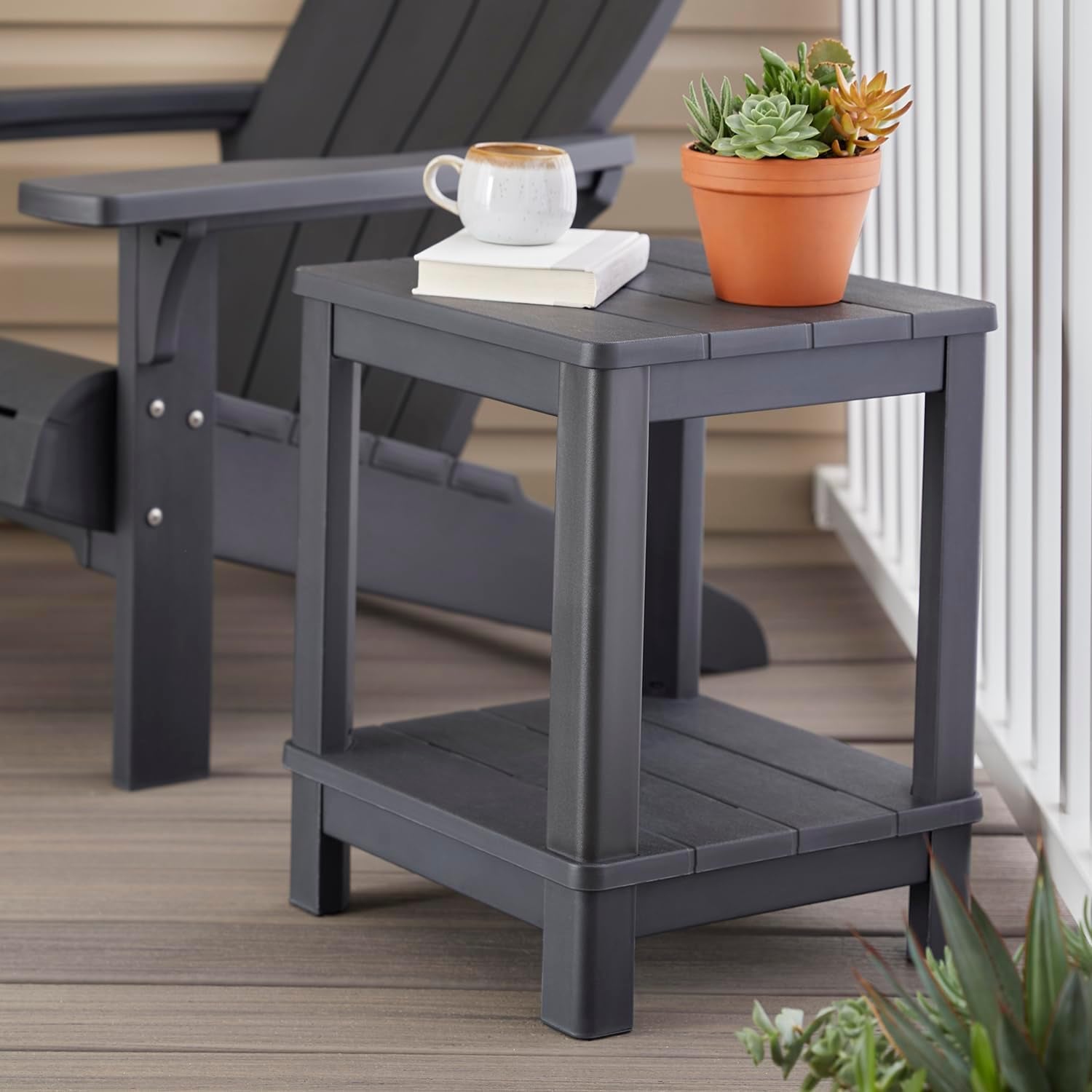 Graphite side table on a porch beside an Adirondack chair holding a mug, book, and potted plant