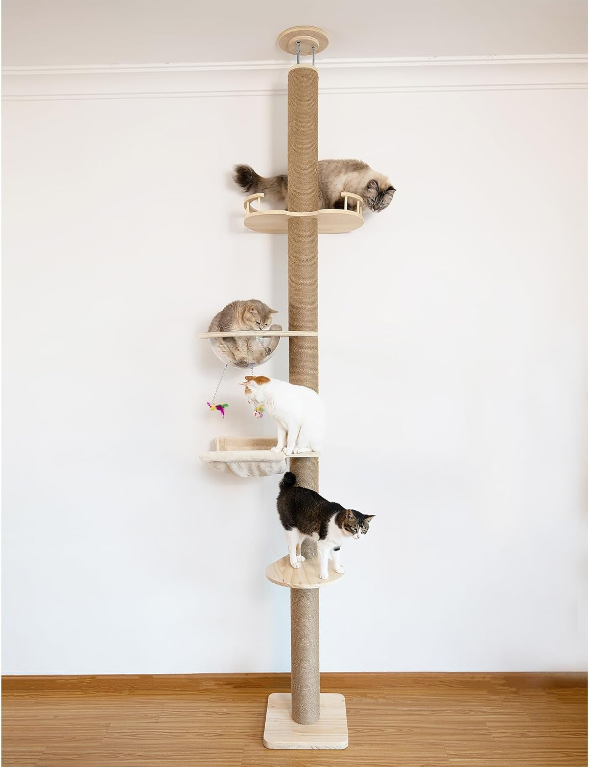 Full view of a tall floor-to-ceiling cat tree with multiple platforms and four cats occupying different levels.