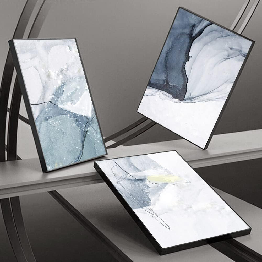 Three framed panels displayed at varied angles on a reflective dark surface showing frame depth and finish