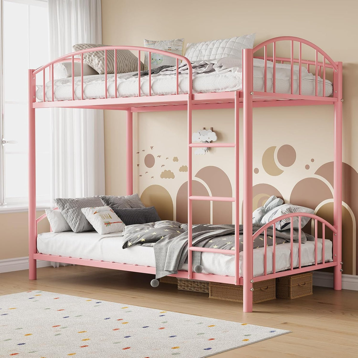 Pink metal twin-over-full bunk bed with ladder in a children's room, patterned rug and wall decals visible.