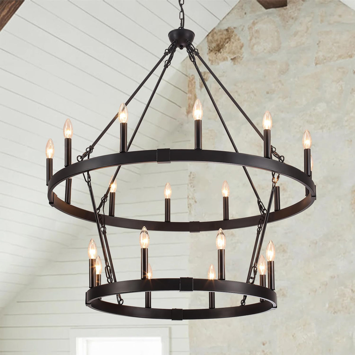 Two-tier matte black metal ring chandelier shown hanging with multiple candle-style lights and chain supports