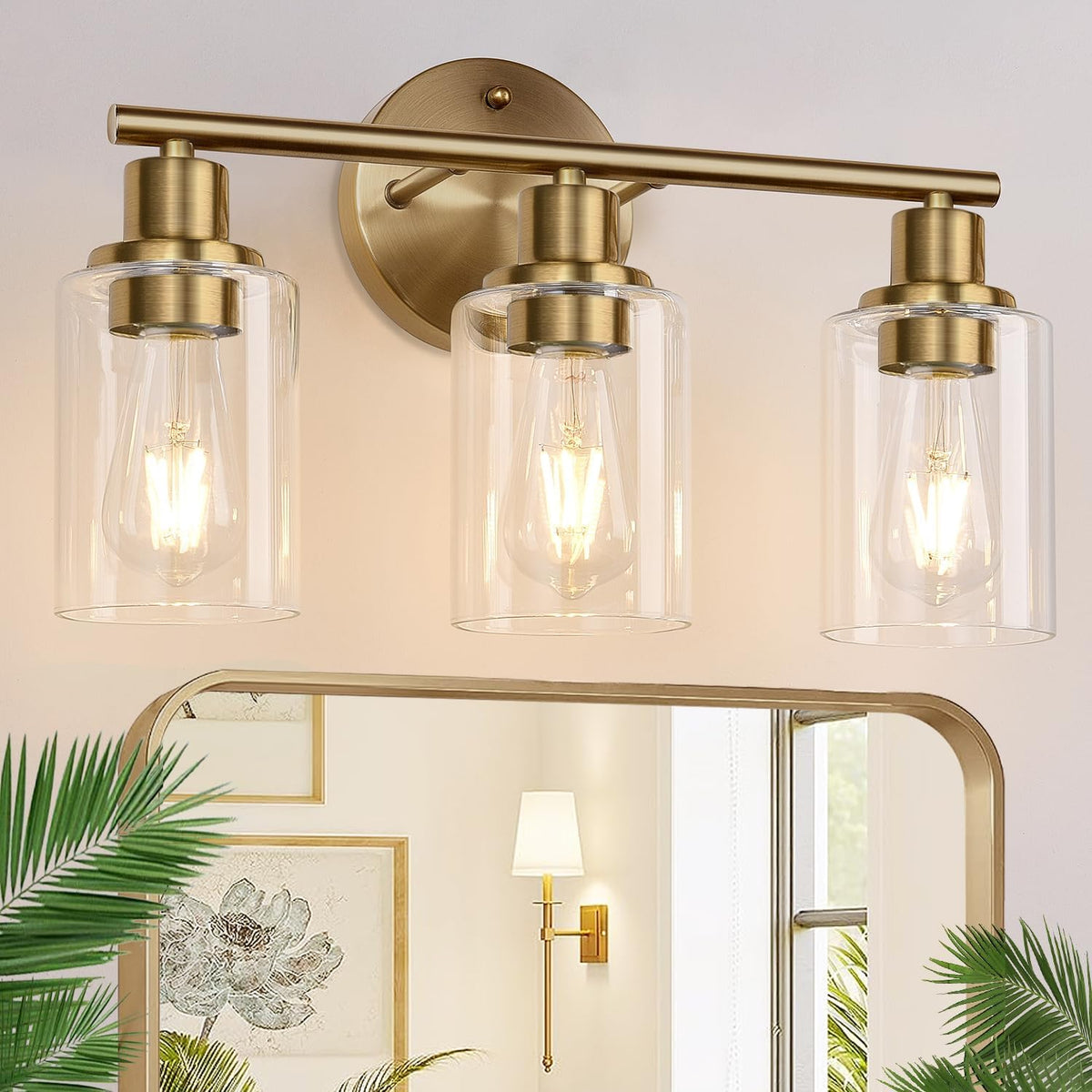 Three-light brass vanity fixture with clear glass shades mounted above a mirror in a bathroom scene