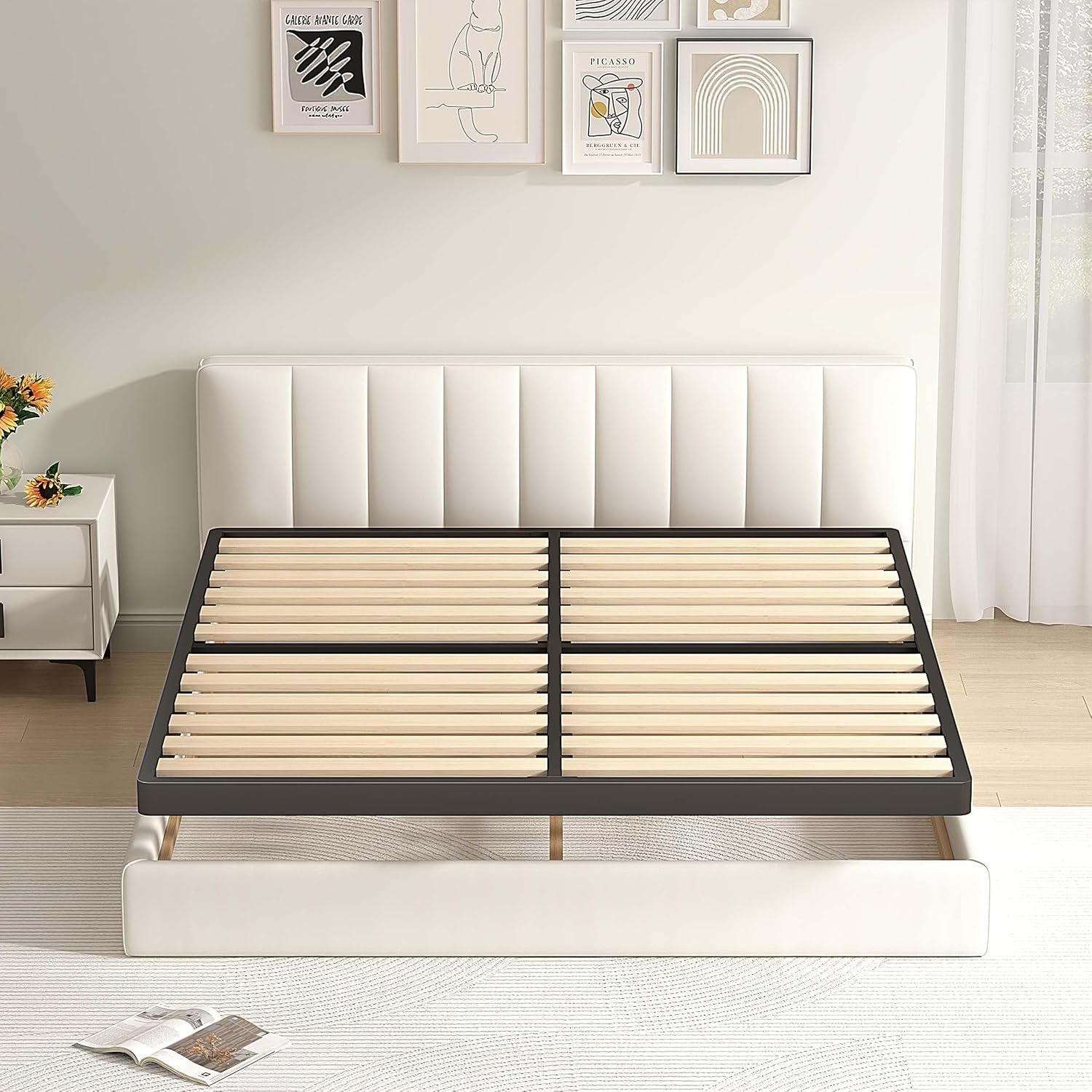 Top-down view of a rectangular black metal frame filled with evenly spaced wooden slats against a white headboard