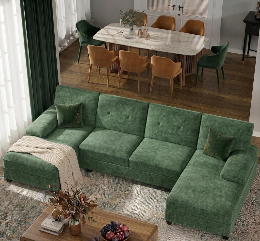 Top-down view of a green U-shaped sectional with two chaises in a living room beside a dining area.