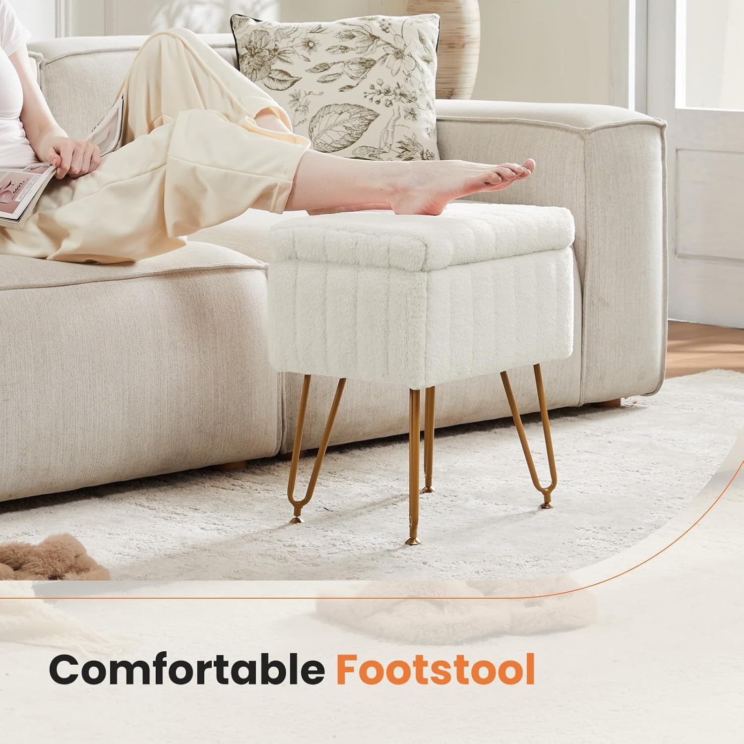 Side view of the white faux-fur footstool with a person resting a foot on top next to a light sofa.