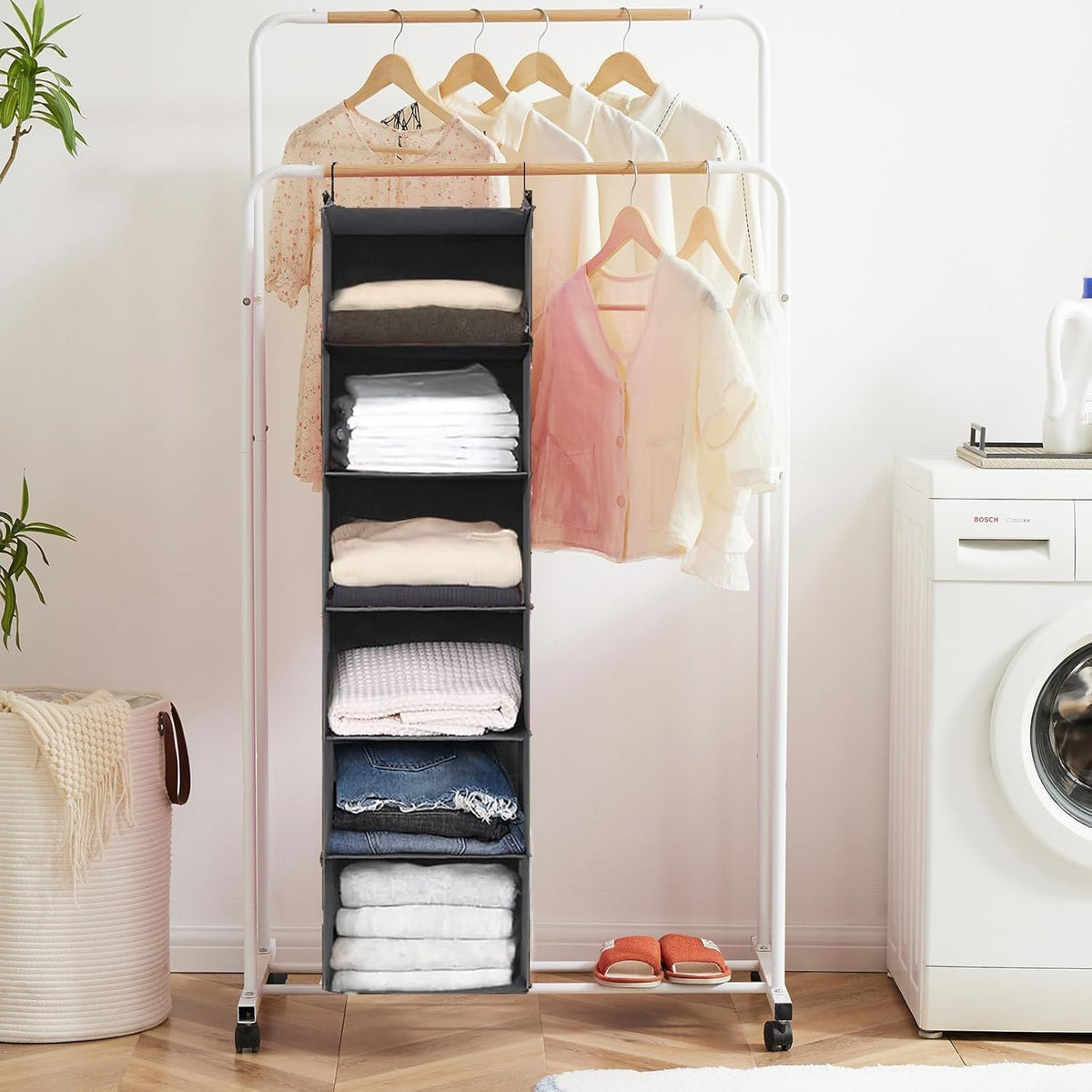Grey hanging organizer in a laundry-room style setting with folded towels and shirts visible on shelves