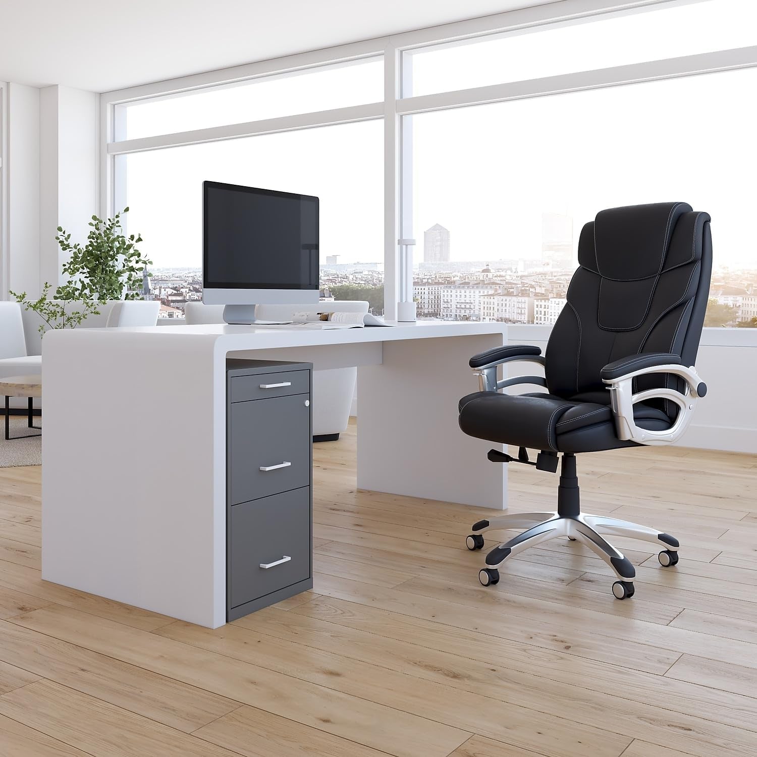 Charcoal three-drawer vertical file cabinet placed under a white desk in a bright office setting