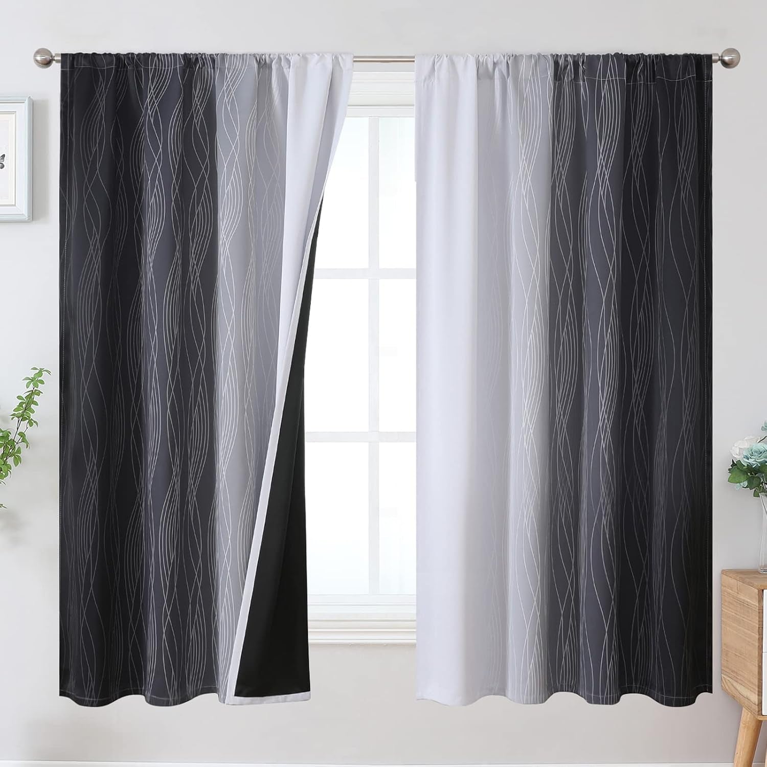 Window framed by dark gray ombre curtains with wavy line pattern, one side opened to show white front and black lining.