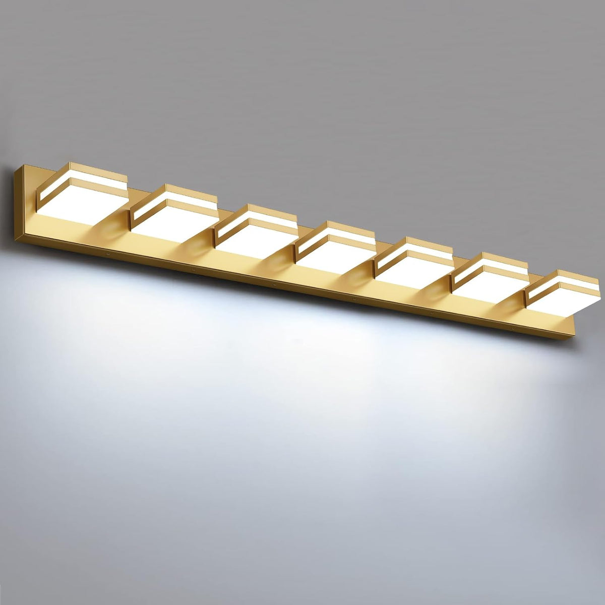 Angled view of the same vanity light in a gold finish with six glowing square modules on a rectangular plate.