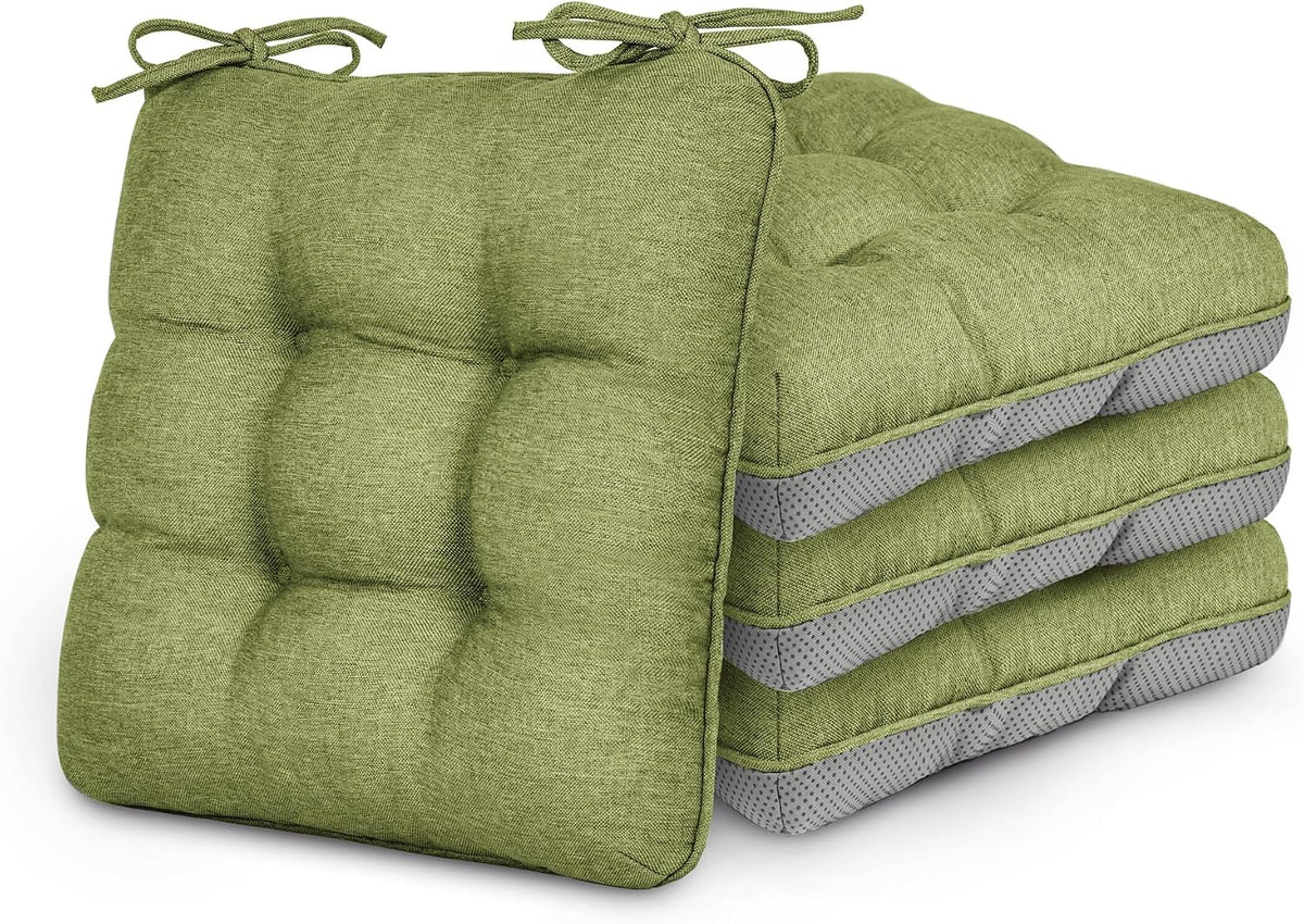 Stack of four tufted green chair cushions with ties, front cushion propped upright.