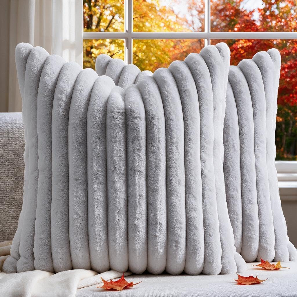 Two light gray ribbed faux-fur throw pillow covers shown upright on a sofa by a window