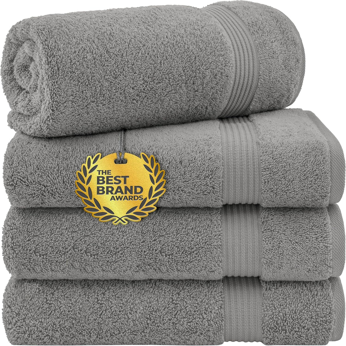 Side view of a rolled towel atop a stacked set of medium-gray towels showing ribbed bands and plush pile.