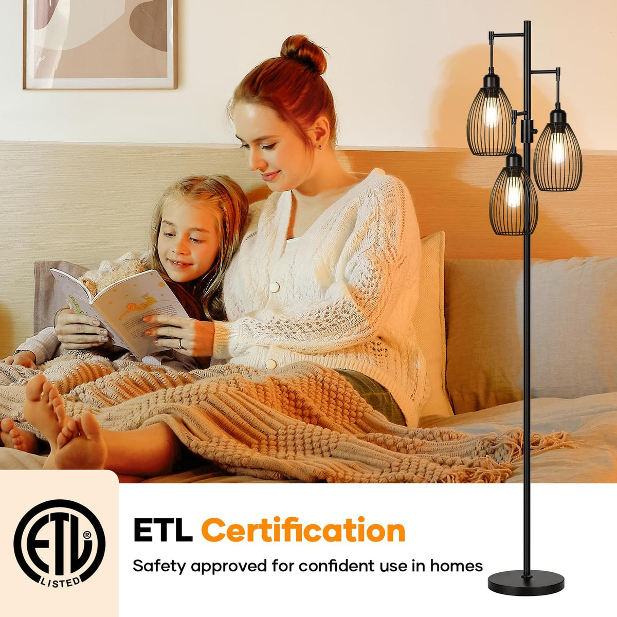 Woman reading to a child on a bed with a lit black three-cage floor lamp standing beside them.