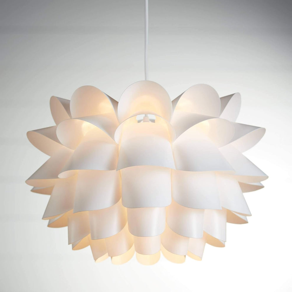 Close-up of white floral pendant light showing layered curved petals and warm interior glow