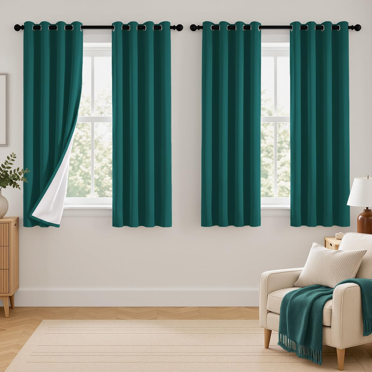 Three short teal curtain panels hung on two nearby windows in a living room scene.