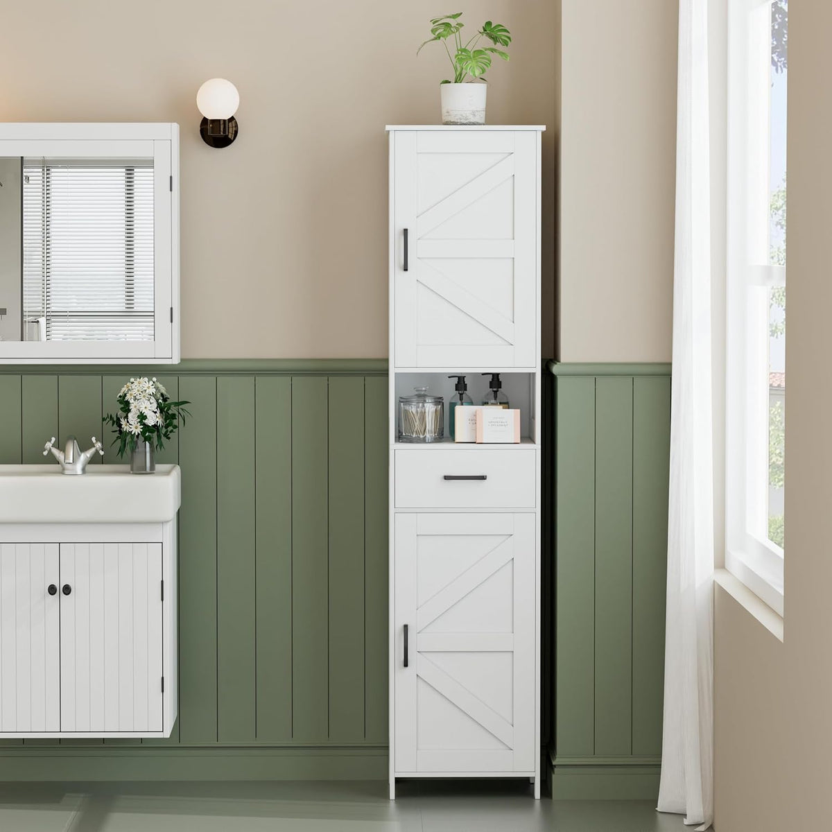 White tall bathroom storage cabinet placed beside a sink and mirror in a styled bathroom, front view