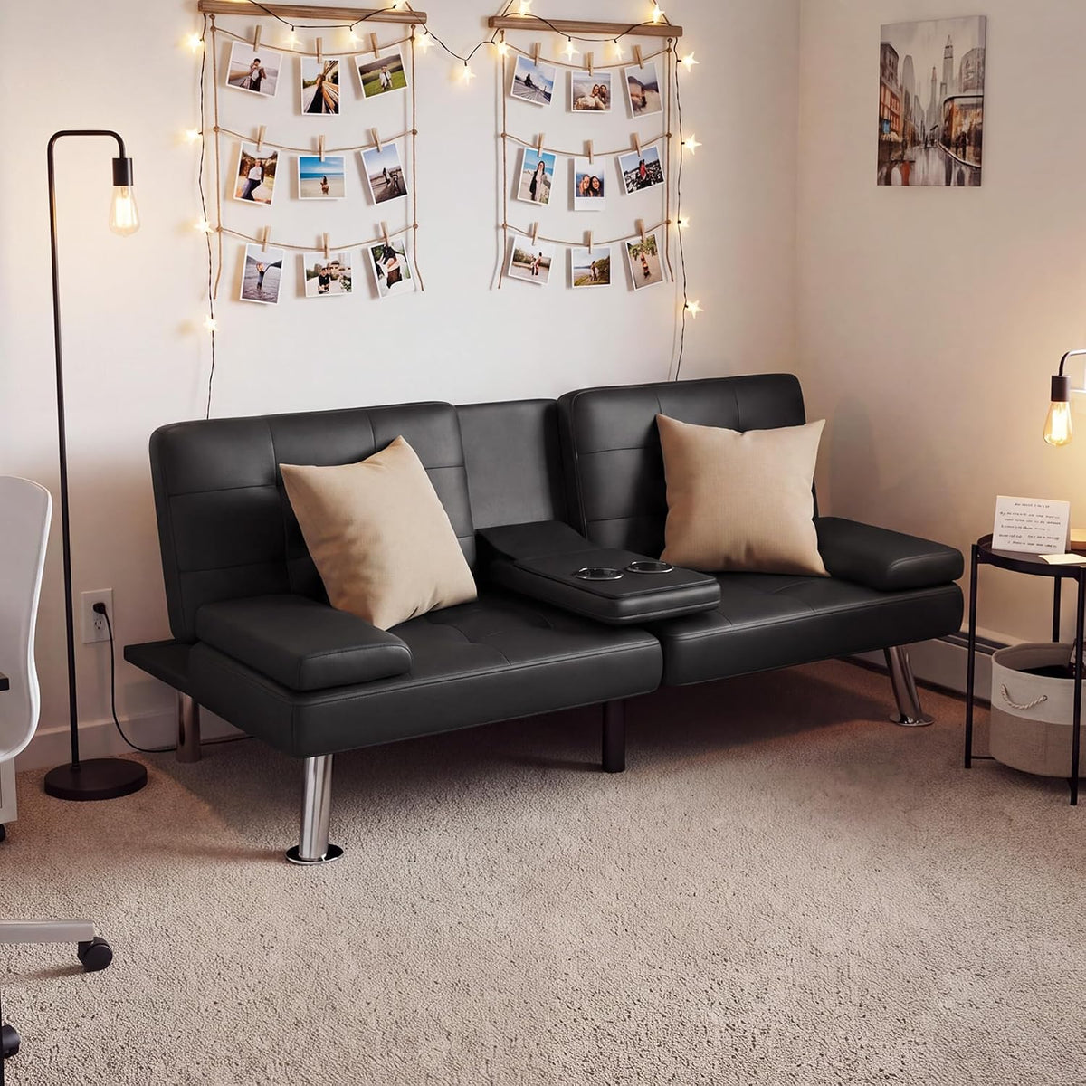 Black futon styled as a sofa with pillows and a center console in a cozy room.