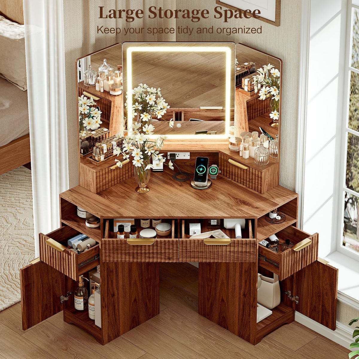 Angled top view of walnut vanity showing illuminated tri-fold mirror, tabletop and open drawers