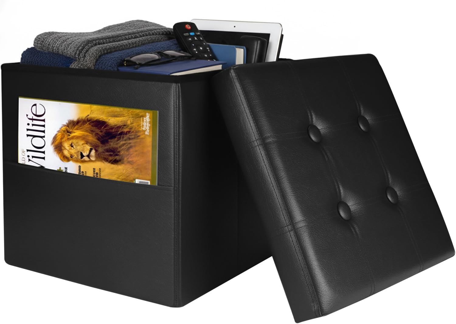 Black faux-leather storage ottoman with lid removed, showing folded clothes and a magazine in the side pocket.