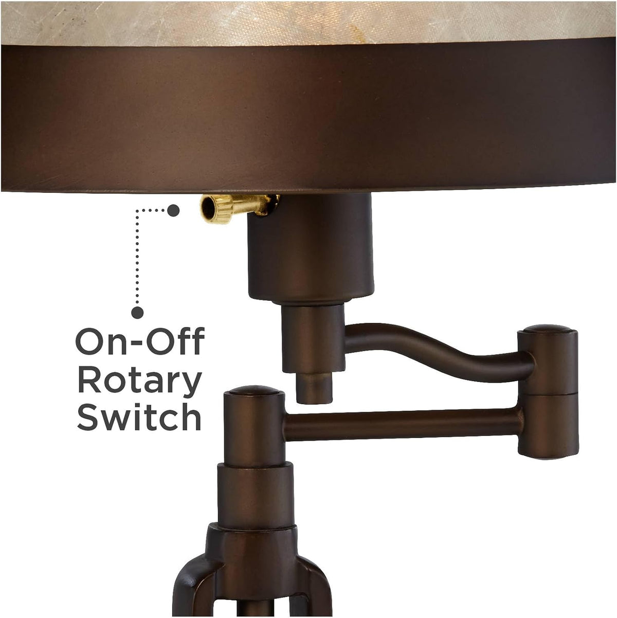 Close-up of the bronze rotary on-off switch and the lamp's articulated arm joint under the mica shade