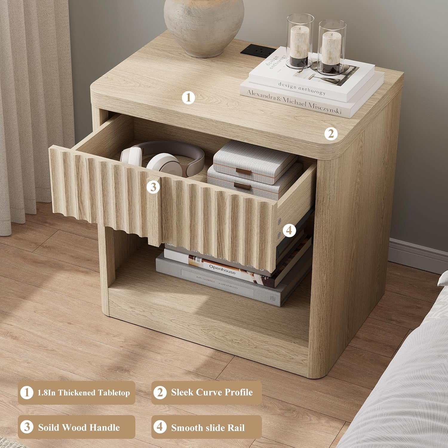 Light wood fluted nightstand with one drawer open, vase and books on the top and shelf with stacked books below.