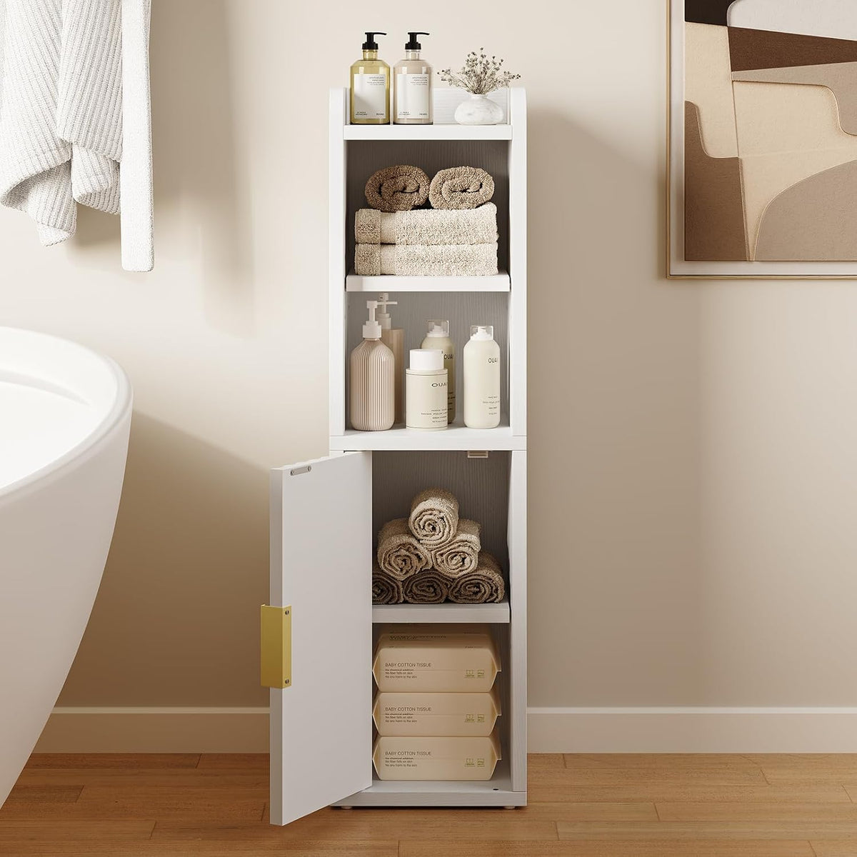 White cabinet with lower door open revealing adjustable inner shelf and storage of towels and packaged goods