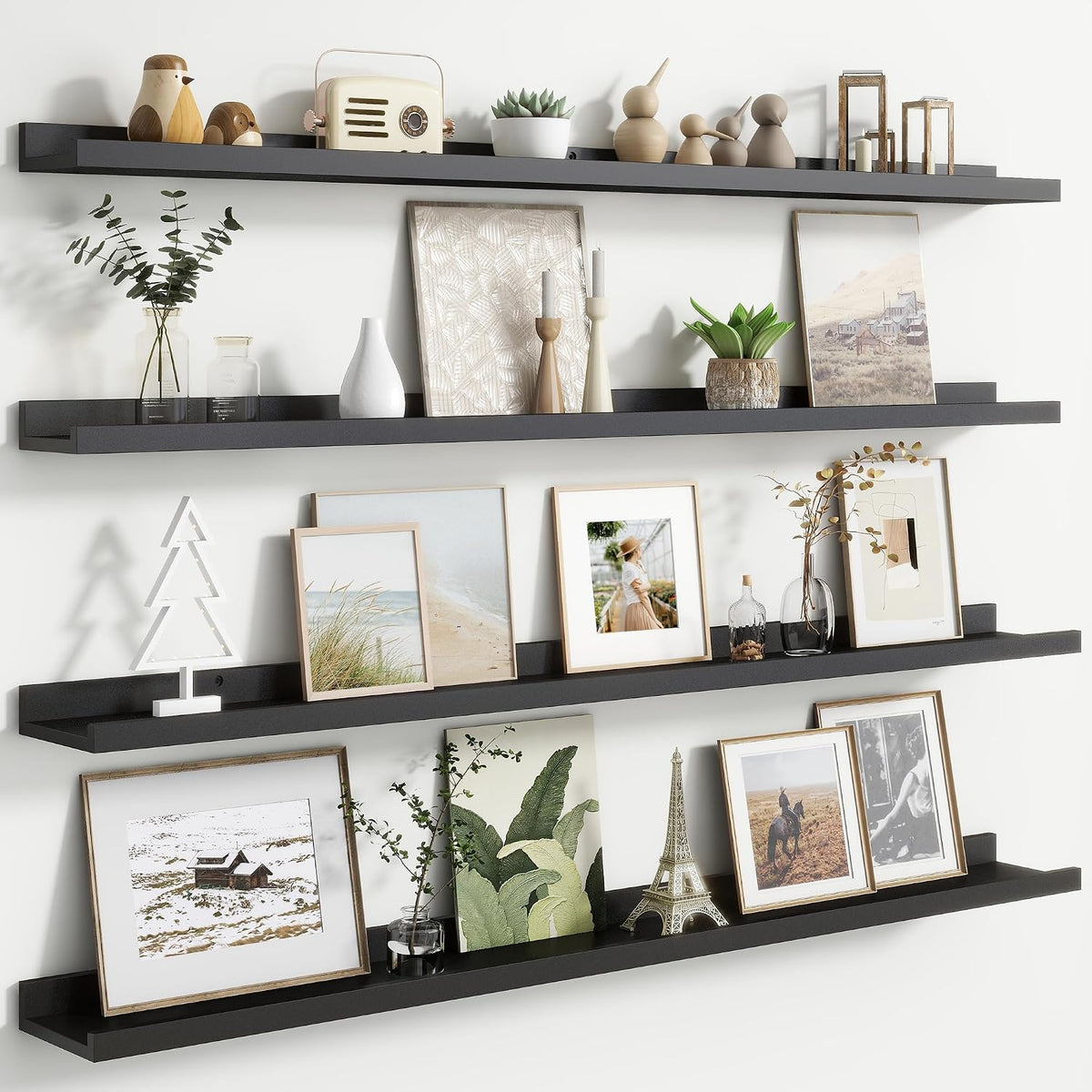 Three long black floating picture ledges mounted vertically with framed photos and decor