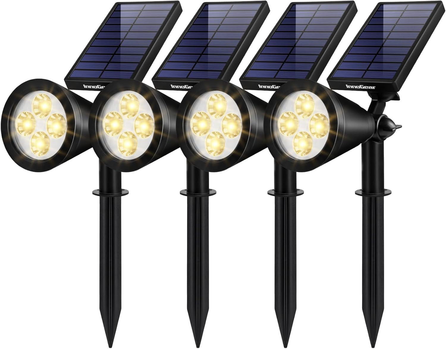Four black solar spotlights with separate rectangular solar panels and ground stakes, front angled view