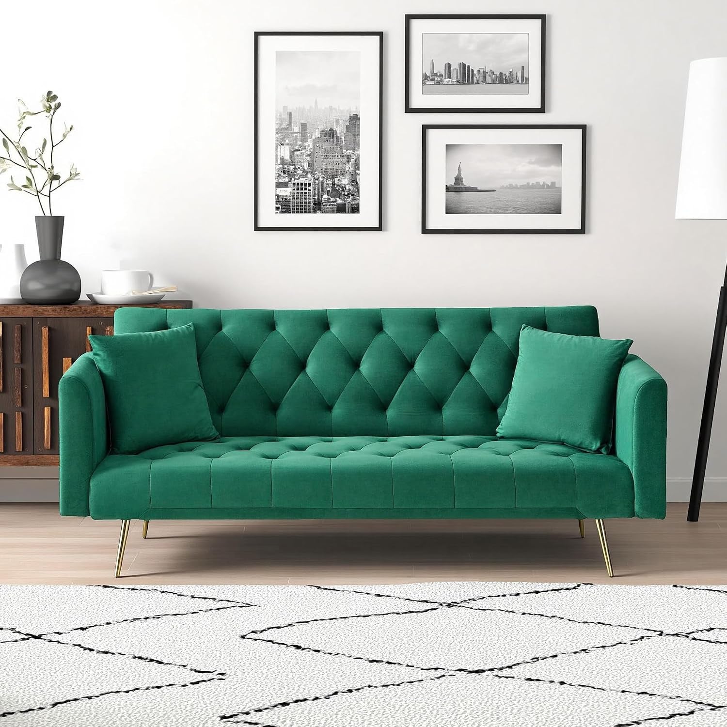Front view of a green tufted velvet sofa with gold tapered legs in a living room setting.