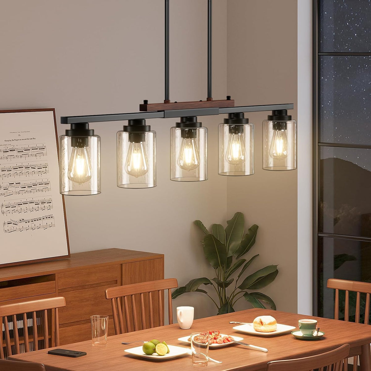 Five-light seeded glass chandelier hanging over a wooden dining table, straight-on view showing lit bulbs