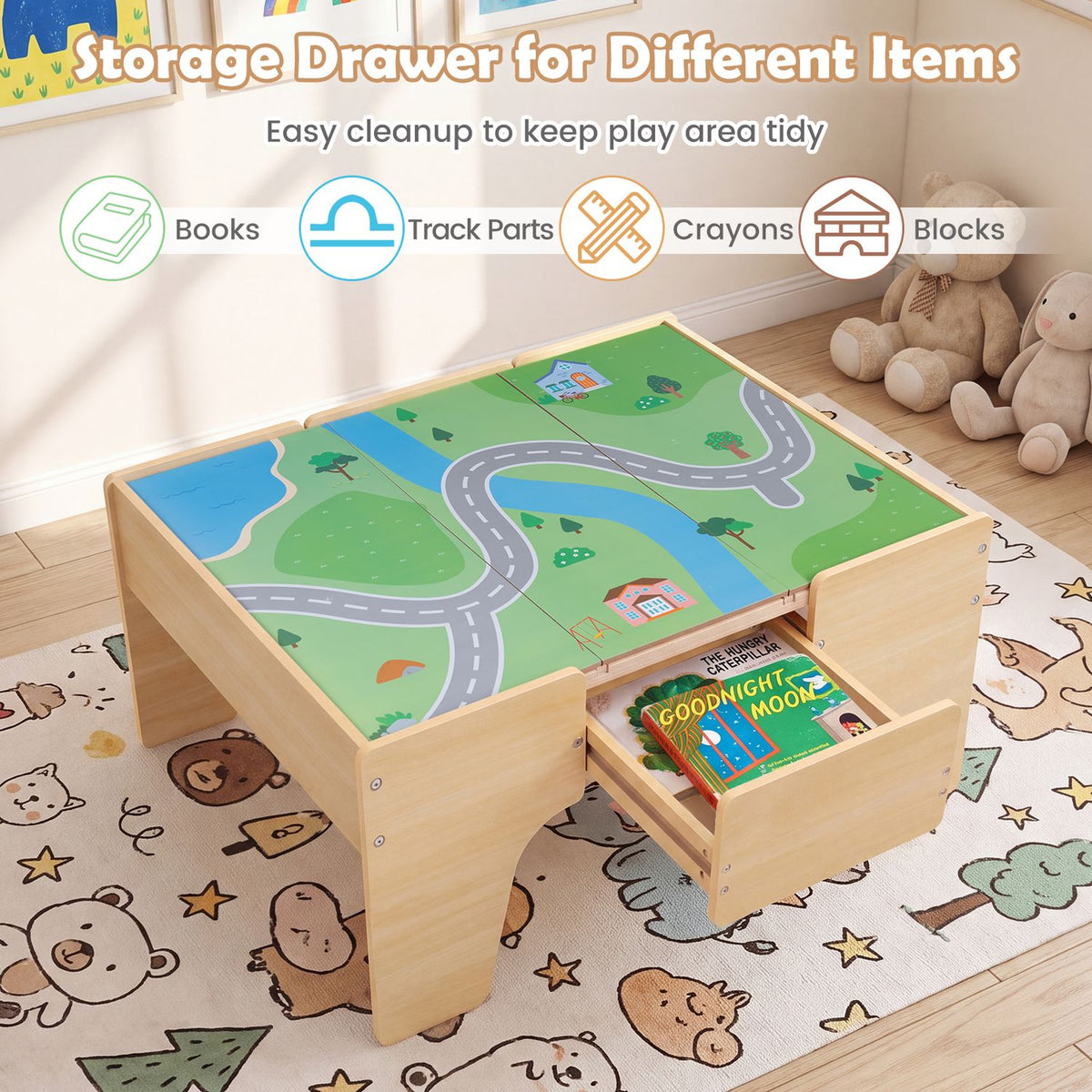 Wooden train table with a road-and-town map top and an open drawer holding books.