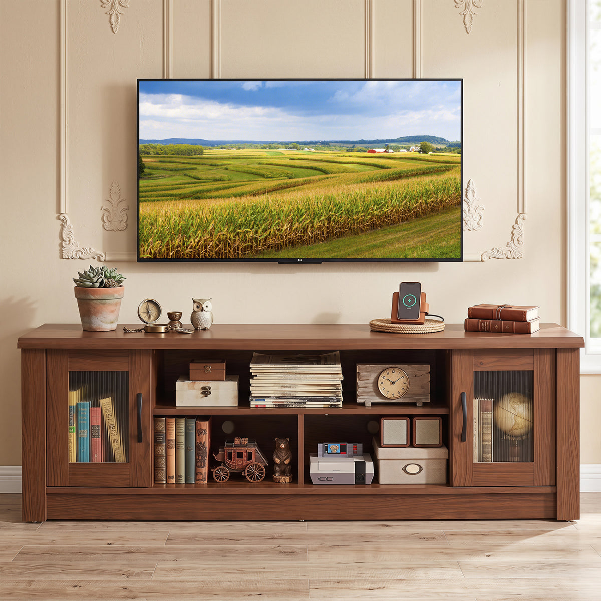 Dark wood TV stand beneath a wall-mounted television, styled with books and decorative objects.