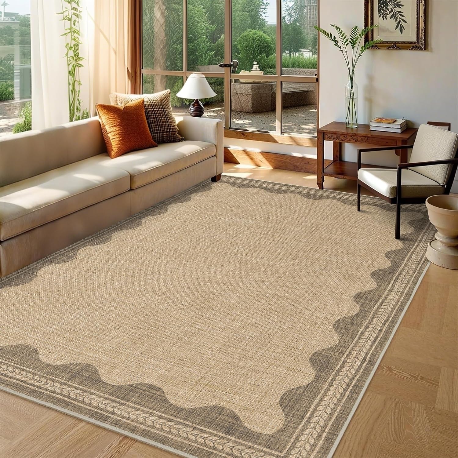 Neutral woven rug with a scalloped darker border covering a bright living room floor by large windows.
