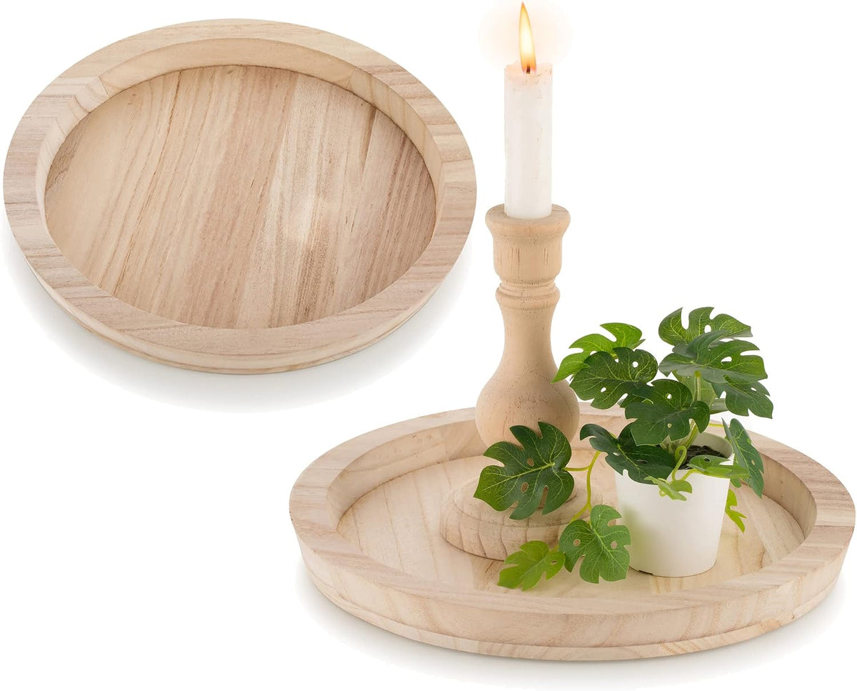 Unfinished natural wood round tray shown empty and with a candlestick and small potted plant