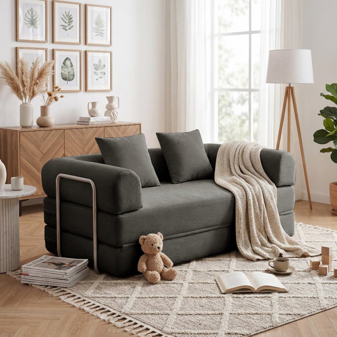 Side/front view of a dark charcoal corduroy convertible sofa with metal side rails and throw blanket